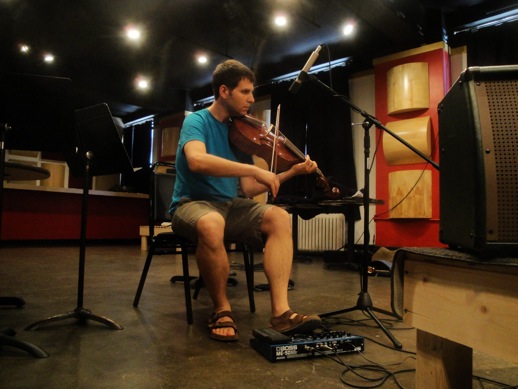 Nissim plays treble viola da gamba under his chin while preparing Nuevos Misterios electronics