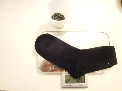 set up for filling the socks with BBs - sock on scale with cup of BBs. Nissim Schaul